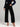 Person wearing a navy velvet top and black wide-leg pants on a plain background