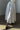 Person wearing a white skirt and black shoes in a minimal indoor setting