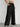Person wearing black wide-leg pants against a white background