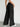 Person wearing black wide-leg pants against a white background, back view