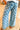 Person wearing blue checkered pants on a wooden floor