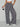 Person wearing leopard print pants on a plain background