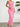 Pink strapless ruffled dress worn by a person against a white wall with a plant