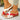 Red and white sandals with brown soles, side view