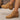 Tan ankle boots worn by a person on a neutral background