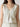 White lace sleeveless top worn by a person on a plain background