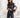 Woman in a black outfit holding a clutch in a minimalistic setting