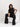 Woman in a black outfit sitting on a white chair