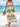 Woman in a long, patterned boho dress standing on a beach with ocean view