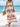 Woman in a long, patterned dress standing on a beach with ocean view
