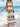 Woman in a maxi boho dress with blue patterns on a beach