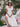 Woman in a white dress and hat sittimg on stone steps with floral decorations