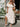 Woman in a white dress holding flowers outdoors
