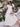 Woman in a white dress holding flowers with a floral and garden background