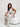 Woman in a white outfit sitting on a white couch