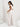 Woman in a white outfit with gold accessories
