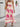 Woman wearing a beige boho dress with pink floral patterns