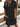 Woman wearing a black button-up dress with a blurred background
