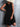 Woman wearing a black dress against a gray textured wall