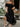 Woman wearing a black off-shoulder dress holding flowers outdoor