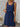 Woman wearing a blue sleeveless dress with a white background