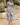Woman wearing a colorful floral dress, front view