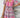 Woman wearing a colorful patterned dress against a wooden background