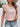 Woman wearing a floral top and denim shorts with a white background
