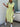 Woman wearing a green and white striped dress with a belt