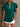 Woman wearing a green blouse with ruffled sleeves and white shorts against a neutral background