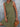Woman wearing a green dress holding a wooden clutch against a gray background