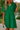Woman wearing a green dress with a blurred natural background