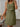 Woman wearing a green dress with a neutral background