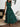 Woman wearing a green dress with black leaf pattern