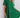 Woman wearing a green dress with ruffled details against a white wall