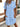 Woman wearing a light blue button-up dress with a blurred background