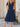 Woman wearing a navy blue dress with short sleeves and pockets, standing outdoors