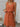 Woman wearing a orange-colored sleeveless dress with a white background