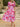 Woman wearing a pink floral dress standing on stone steps outdoors