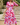 Woman wearing a pink floral dress standing outdoors on stone steps