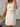 Woman wearing a white checkered dress with a blurred background