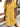 Woman wearing a yellow dress with short sleeves and buttons, standing outdoors