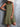 Woman wearing an olive green dress against a gray background
