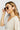 Woman wearing sunglasses with a plain background