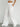 Woman wearing white wide-leg drawstring pants with front pockets, styled with crop top