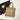 Woven tote bag with leather handles on a white surface with a black jacket and ceramic cup