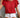 Person wearing a red ruffled top and white shorts against a neutral background