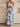 woman wearing a blue and white patterned dress in a minimalistic setting