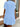 women wearing a light blue dress standing near a glass door